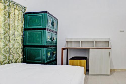 - une chambre avec un lit et une armoire verte dans l'établissement OYO Life 93138 Anugrah Kost Syariah, à Bandar Lampung