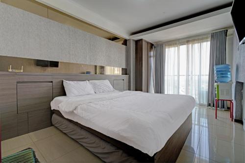 Schlafzimmer mit einem großen weißen Bett und einem Fenster in der Unterkunft OYO Life 93097 Apartemen Gateway Pasteur By Kaisar Room in Bandung