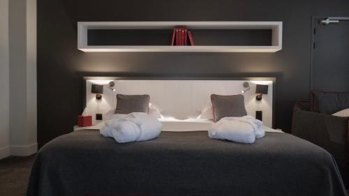 a bedroom with a bed with two white pillows at Le Faucigny - Hotel de Charme & SPA in Chamonix-Mont-Blanc