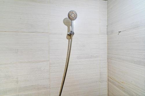 a shower head in the corner of a bathroom at OYO Life 93065 Apartemen Gateway Pasteur By Glory Rent in Bandung