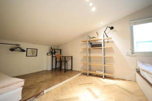 a attic room with a staircase and a floor at SISnBRO Guesthouse in Seoul