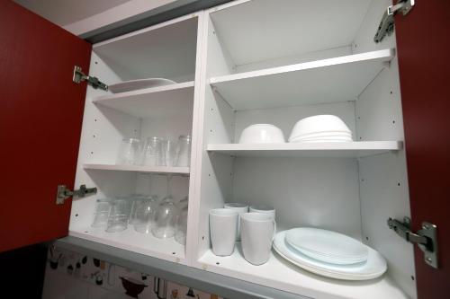 um armário branco com pratos e pratos em Confortevole appartamento playa del ingles em Maspalomas