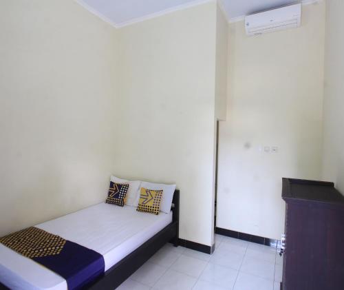 a small bedroom with a bed with pillows on it at OYO Life 93155 Wisma Sarah in Tanjung