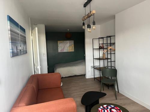 een woonkamer met een bank en een bed bij Appartement comme à la maison refait à neuf in Boulogne-sur-Mer