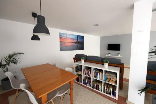 uma sala de jantar com uma mesa e uma estante de livros em Confortevole appartamento playa del ingles em Maspalomas