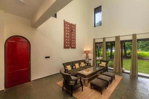 a living room with a couch and a table and chairs at SaffronStays Amavi Beach House in Dapoli