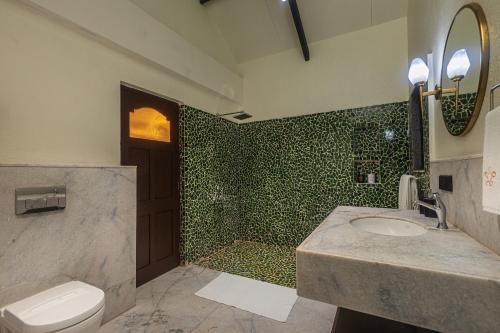 a bathroom with a toilet and a sink and a shower at SaffronStays Amavi Beach House in Dapoli