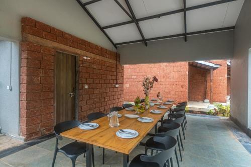 a dining room with a long table and chairs at SaffronStays Amavi Beach House in Dapoli