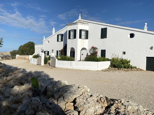 a large white building with black shutters on it at Holiday Home Finca SANT JAUME in Alaior