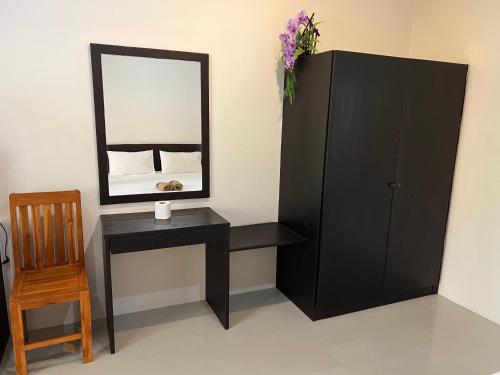 a bedroom with a black cabinet and a mirror at Dow Residance in Koh Samui 
