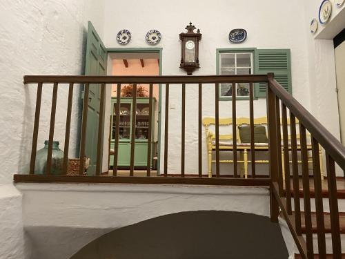 a balcony with a clock on a house at Holiday Home Finca SANT JAUME in Alaior