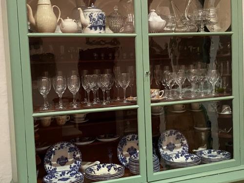 a glass cabinet filled with glasses and plates and vases at Holiday Home Finca SANT JAUME in Alaior