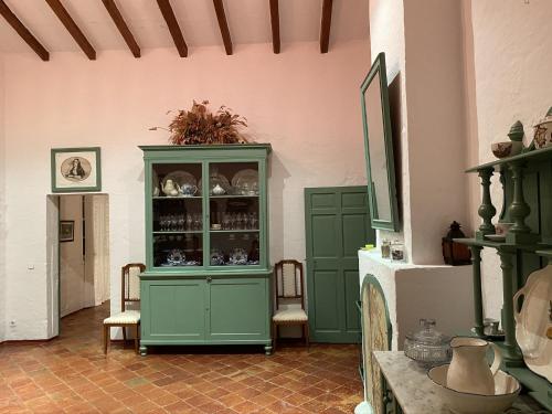 a room with a green cabinet and two chairs at Holiday Home Finca SANT JAUME in Alaior