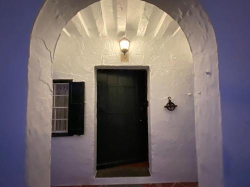 a hallway with a black door with a light above it at Holiday Home Finca SANT JAUME in Alaior