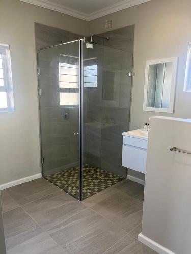 una ducha con puerta de cristal en un baño en Silwer, en Struisbaai