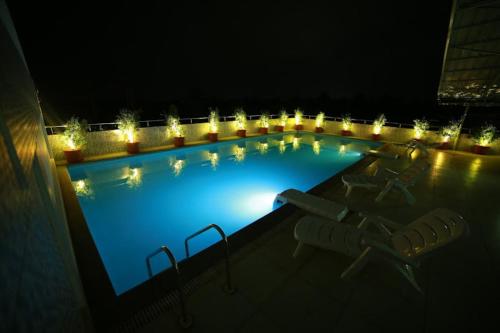 a large swimming pool at night with lights at Nakshatra Emerald in Guruvāyūr