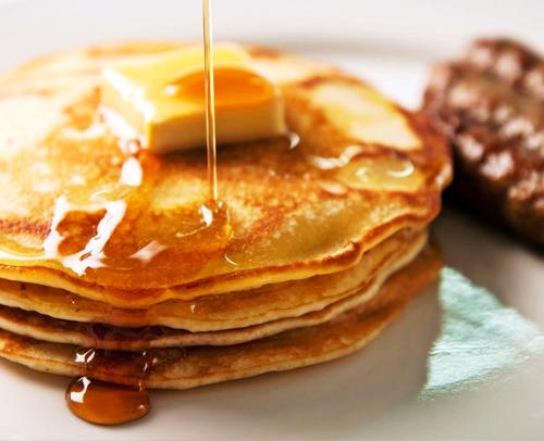 a stack of pancakes with butter and syrup on a plate at Hotel Panamonte in Boquete