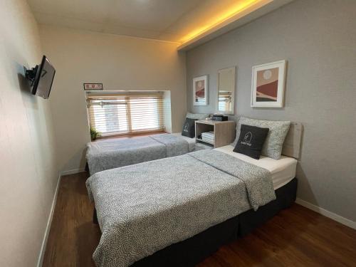 a room with three beds and a desk in it at Seoul Grand Hostel EWHA Univ in Seoul