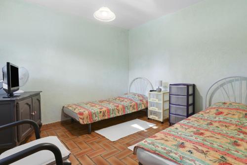 une chambre avec deux lits et une télévision dans l'établissement Rez de Jardin dans Villa, à Saint-Raphaël