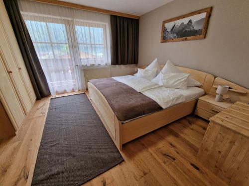 a bedroom with a bed and a large window at Ferienlandhaus Höfer in Fulpmes