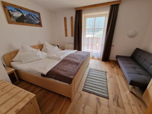 a bedroom with a large bed and a couch at Ferienlandhaus Höfer in Fulpmes