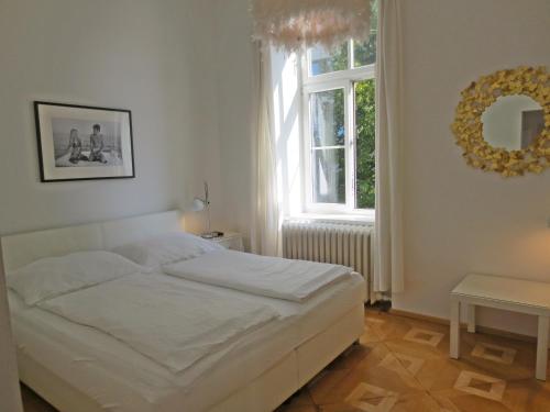 a bedroom with a white bed and a window at WOLKE, Apartment oder Doppelzimmer, Zentrum, am Fluss, Parkplatz in Bad Ischl