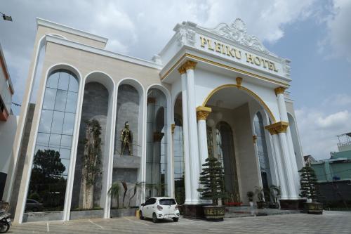 um carro branco estacionado em frente a um edifício em Pleiku Hotel by Gia Lai Tourist em Plây Ku