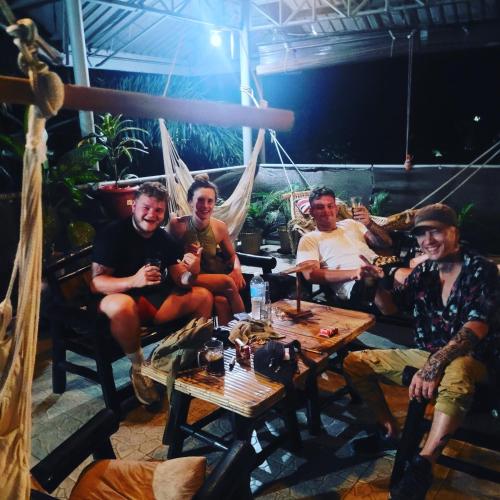 a group of men sitting around a table at La Vida Hostel in Puerto Princesa City