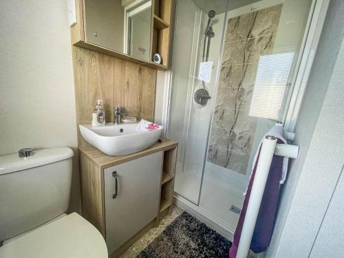 y baño pequeño con lavabo y ducha. en Spacious Caravan With Large Decking Area, Perfect To Enjoy The Sun, Ref 23058c, en Hunstanton