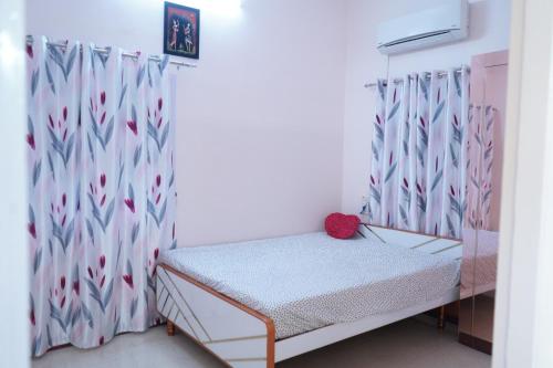 a small bed in a room with a curtain at Visalam service apartment in Chennai
