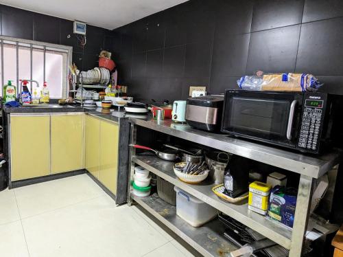 a kitchen with a counter with a microwave and a sink at Meow! Marcia Youth Hostel in Pingtan