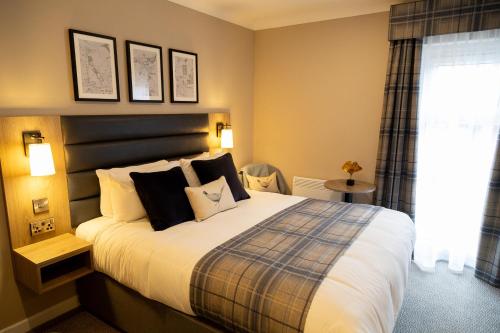 a bedroom with a large bed and a window at De Vere Horsley Estate in Leatherhead