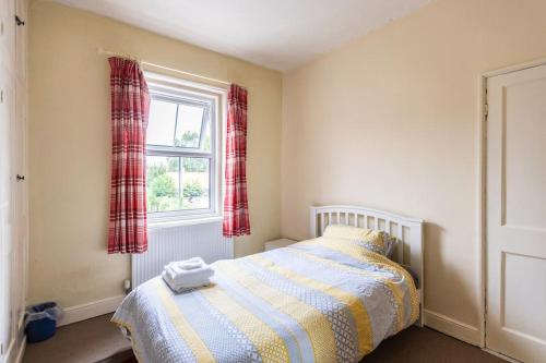 a small bedroom with a bed and a window at Park View House - Sleeps 6 in York