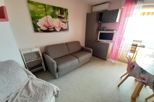 a living room with a couch and a table at Latte mer in Palavas-les-Flots