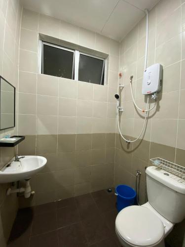La salle de bains est pourvue de toilettes et d'un lavabo. dans l'établissement Razumi's Homestay, à Arau