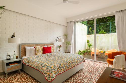a bedroom with a bed and a large window at La Meira 3BHK Villas in Assagao with Private Pool, Garden, Caretaker, Kitchen & Security in Vagator