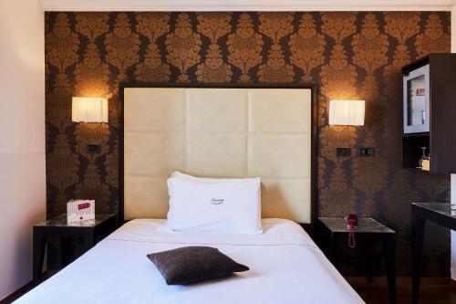 a hotel room with a bed with a pillow on it at Hotel Touring in Bologna