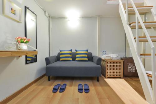 a living room with a blue couch and a ladder at Bedever Boutique Bangkok Hotel - BTS Phra Khanong in Bangkok