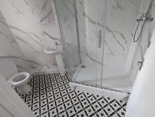 a bathroom with a shower and a toilet and a sink at RAHAL HACKNEY in London