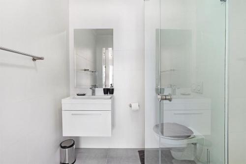 a white bathroom with a sink and a shower at The Paragon Explore Cape Town from a Stylish Home in Cape Town