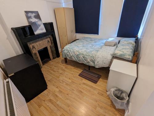 1 dormitorio pequeño con 1 cama y chimenea en RAHAL HACKNEY en Londres