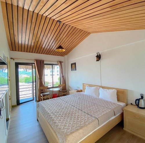 Schlafzimmer mit einem Bett mit Holzdecke in der Unterkunft Catba Oasis Bungalows in Cát Bà