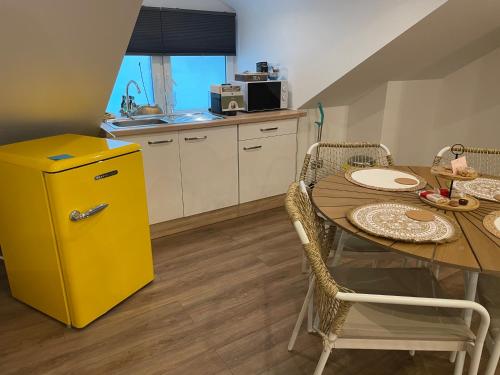 a yellow refrigerator in a kitchen with a table at Hallo Maastricht B&B Fientje in Maastricht