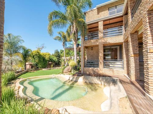 a brick house with a swimming pool in front of it at Aan de Paarlberg in Paarl