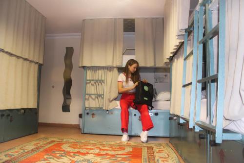 a woman sitting on a bench in a room at Agora Guesthouse in Istanbul
