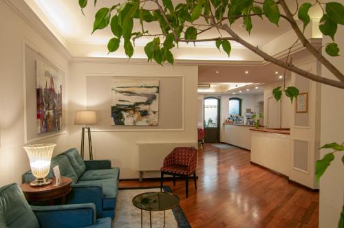 a living room with a blue couch and a table at Hotel Touring in Bologna