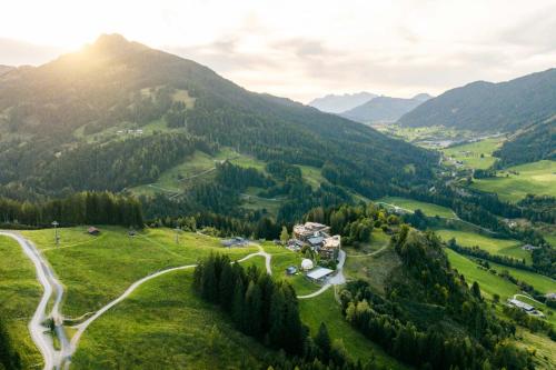 a view of a valley with a house on a hill at Holzhotel Forsthofalm in Leogang