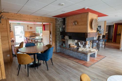 a dining room with a fireplace and a table and chairs at Hôtel Les Arches in Saint-Lary-Soulan