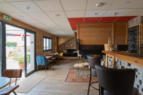 a restaurant with a bar and tables and chairs at Hôtel Les Arches in Saint-Lary-Soulan