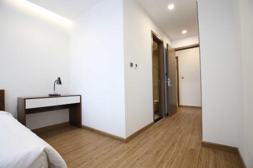 a bedroom with a bed and a table and a mirror at Investland- Vinhomes Metropolis one, two, three, four bedrooms in Hanoi